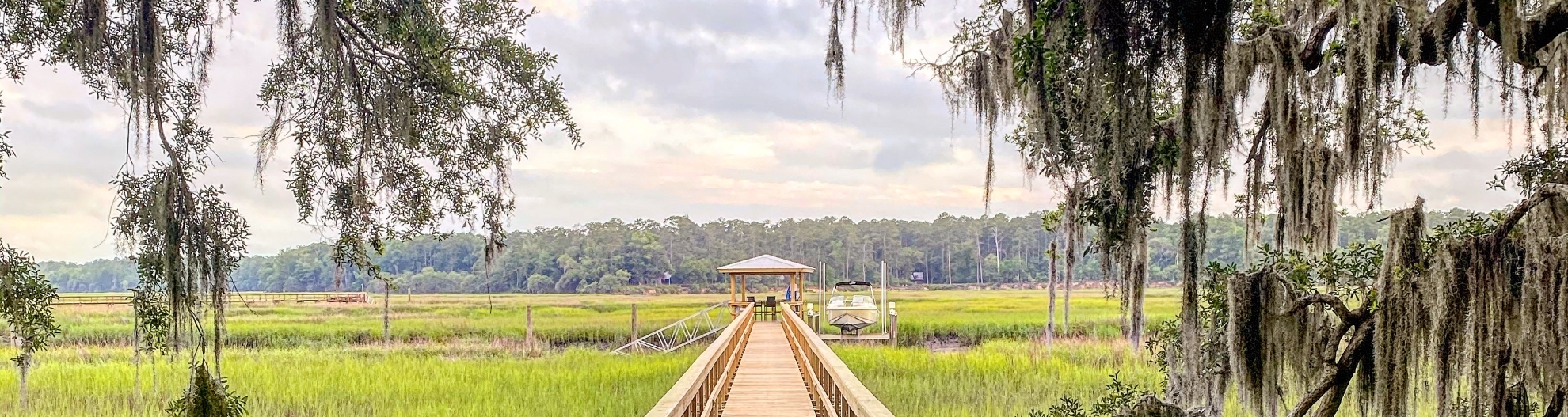 View of looking down a dock with weeping willows in South Carolina